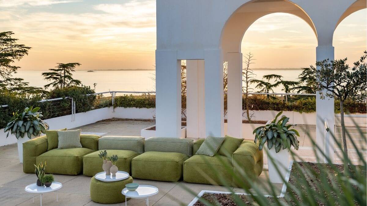 Divano in tessuto verde ambientato in un giardino di una villa al mare